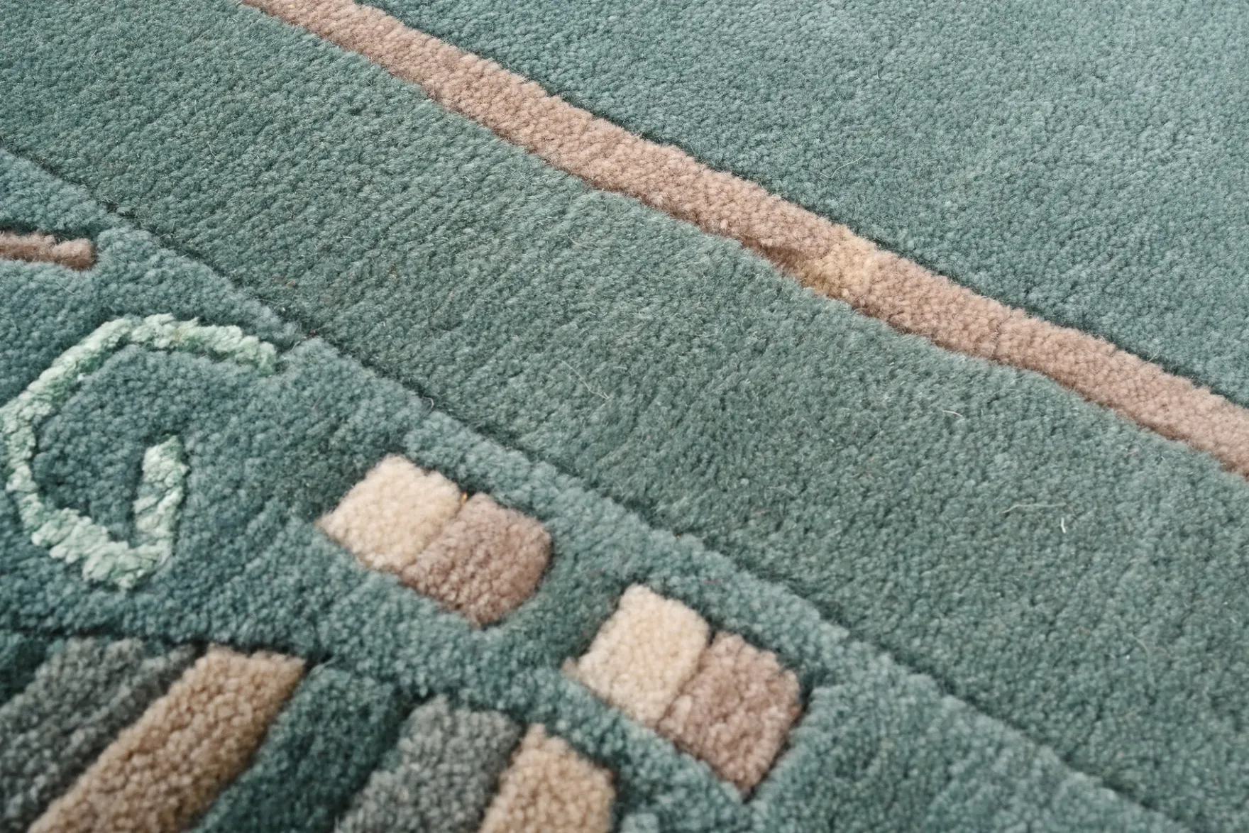 Handgeknüpfter Tibeter Teppich in grün mit Retro Bordüre – Neuwertig