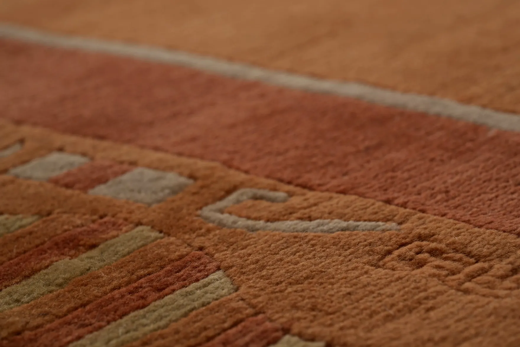 Handgeknüpfter tibetischer Teppich in rot braun mit Retro Bordüre – Neuwertig